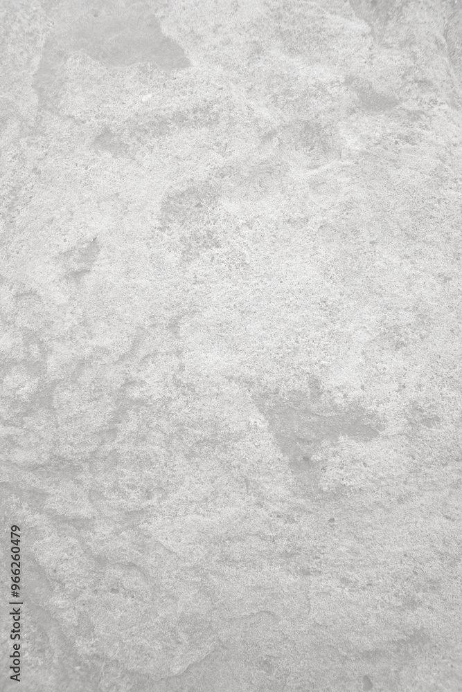Fototapeta premium Light grey rough stone wall for abstract background and texture for interior or exterior design. Beautiful patterns, space for work, banner, wallpaper close up.Vertical.