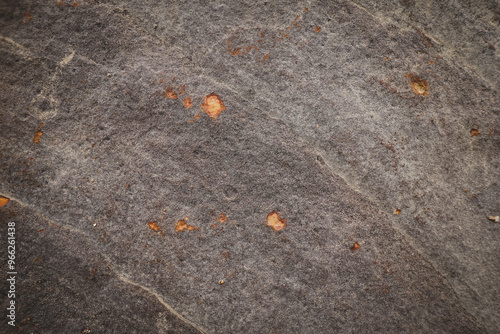 Grey rough stone wall with peeling of stone surface orange rusted cracks for abstract background and texture, interior or exterior design. Beautiful patterns, space for work, banner, wallpaper.  photo