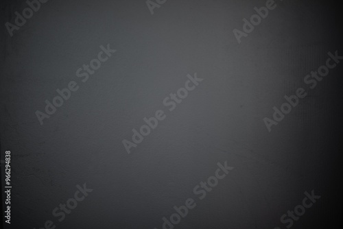 Close-up of a plain dark gray wall with a smooth, slightly textured surface. The minimalist and neutral background is perfect for use in design, presentations, or as a backdrop for creative projects photo