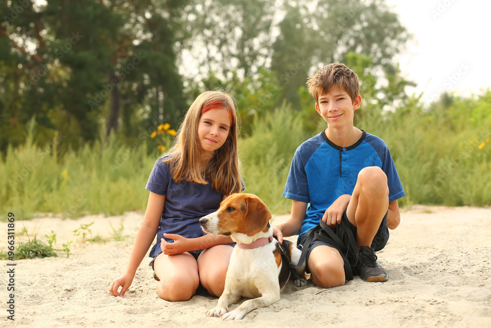Fototapeta premium Children walking their estonian hound pet on the beach