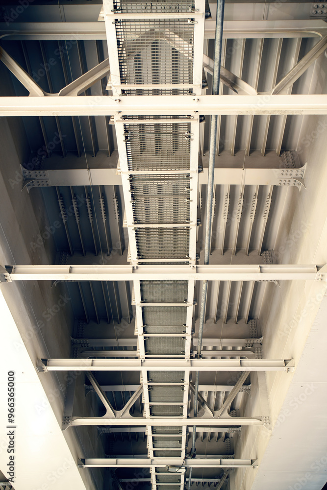 Fototapeta premium towering bridge with a steep stairway, designed for workers to access the upper levels. It symbolizes human engineering, teamwork, and the pursuit of progress