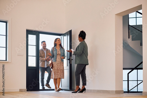 Happy couple meeting with their real estate agent during open house day.