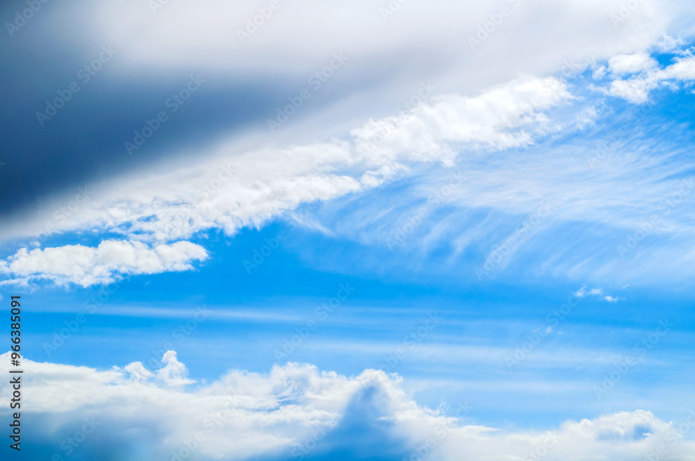 Fototapeta premium Dramatic blue sky background. Picturesque colorful clouds lit by sunlight. Vast blue sky landscape panoramic scene