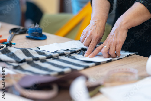 Cropped view of woman seamstress giving sewing lesson at dressmaker course