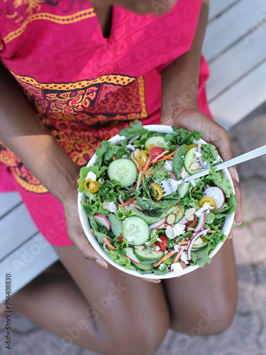 Woman holding large green salad. photo