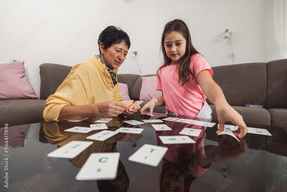 Fototapeta premium Grandmother and Granddaughter Playing Card Game
