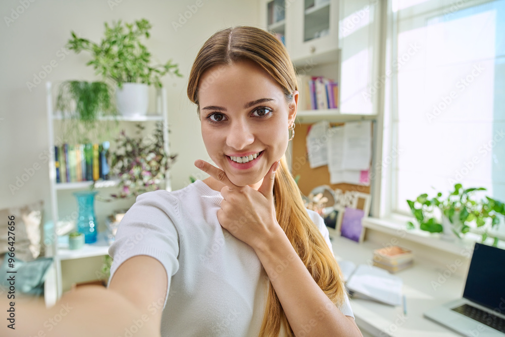 Close-up selfie portrait of teenage cheerful female looking at web camera Close-up selfie portrait of teenage cheerful female looking at web camera