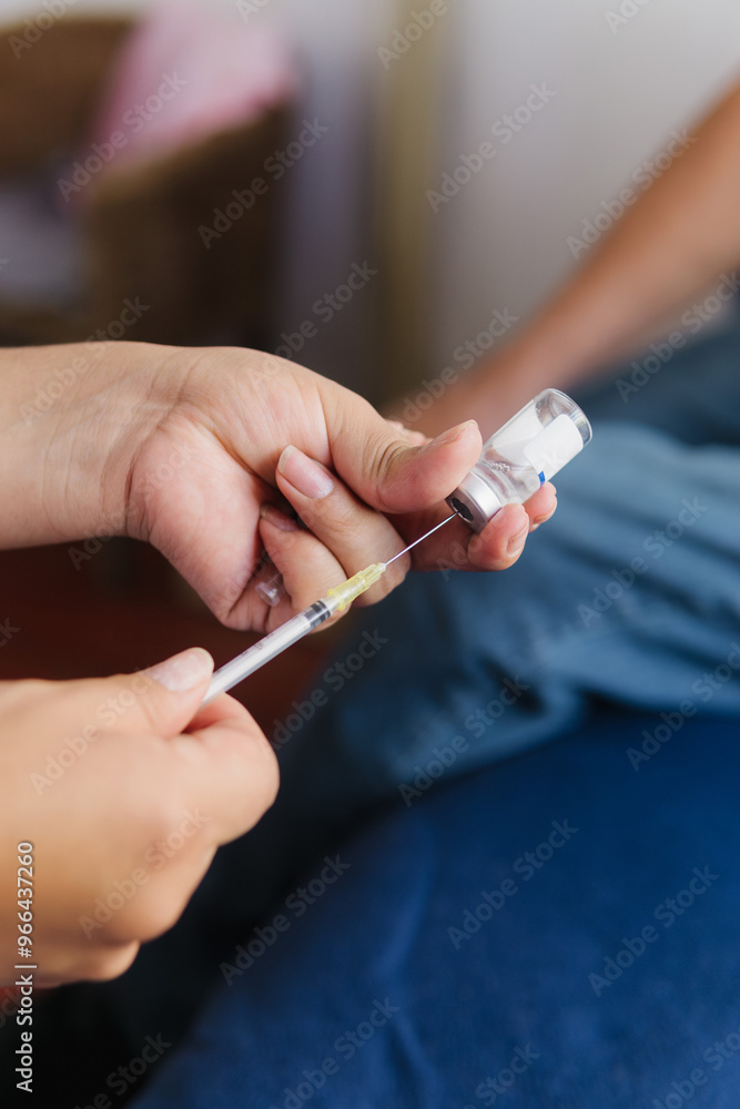 Close-up of the hands of an unrecognizable person preparing a syringe. Close-up of the hands of an unrecognizable person preparing a syringe.