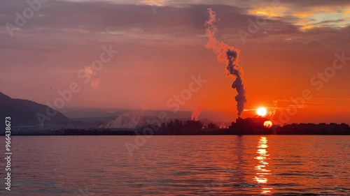 Smoke Pollution at sunset by the sea, Harmful fumes coming from factory chimney at sunset photo