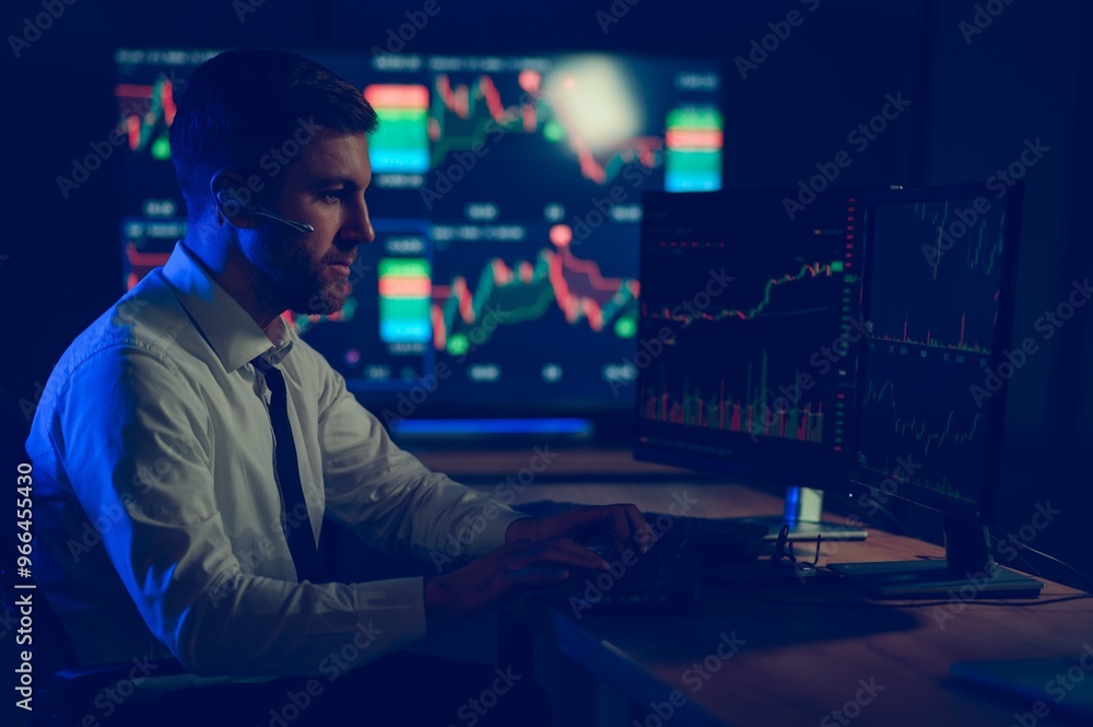 Financial Analyst. Businessman Works in Investment Bank Downtown Office at Night Financial Analyst. Businessman Works in Investment Bank Downtown Office at Night