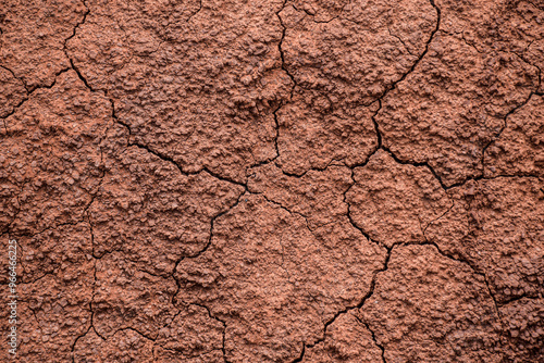 Cracked dry red clay soil background photo