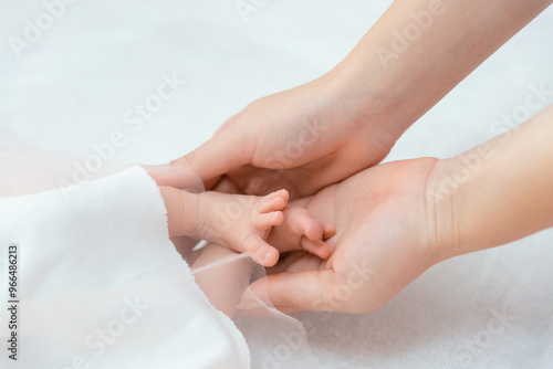 Wallpaper Mural Gentle mother hand holding the legs of a newborn baby. Torontodigital.ca