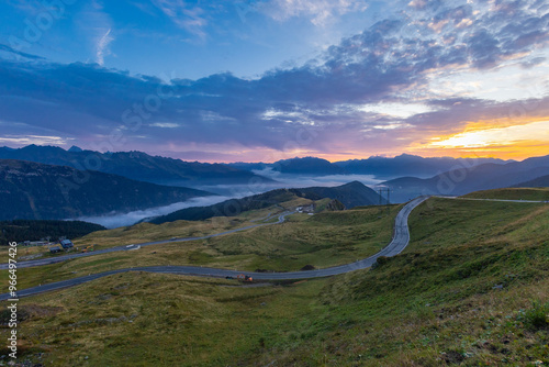 Beautiful early Morning panorama from Jaufenpass or Passo Giovo, 2100m high alpine road pass in northern italy. Beautiful sunrise, hazy valley,mist rising up, a pretty sight photo