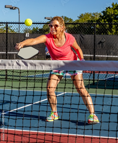 Female pickleball player shows who to do the bakhand volley photo