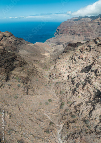 Aerial view of the trail through the mountains to Guigui beach, pristine black sand beach, Gran Canaria. Spain. Scenic trail
 photo