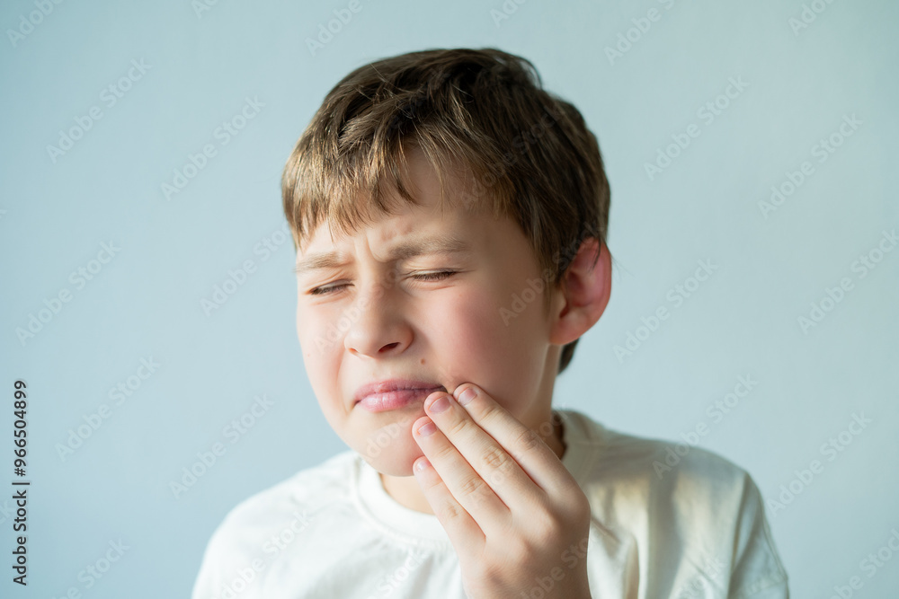 Toothache. 10 year old boy holds his face with his hand. Home. Toothache. 10 year old boy holds his face with his hand. Home.