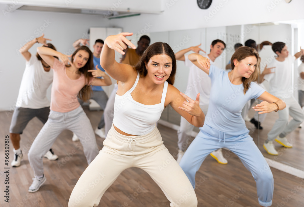 Fototapeta premium Group of positive dancers repeat dance in dance hall