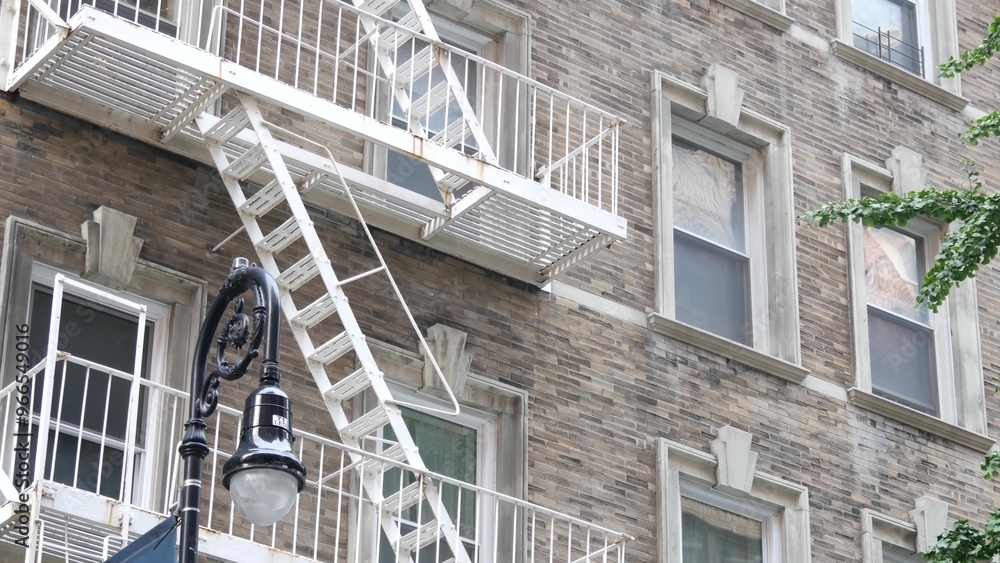 Fototapeta premium New York City classic building architecture. Urban residential house exterior. Real estate property in USA. Typical brick facade in United States. Fire escape, emergency ladder exit.