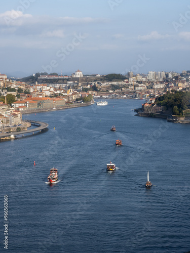 View of the Arrábida Bridge, with 5 rabelo boats, the typical Portuguese vessel on the Douro River, now used for tourist trips. Porto, Portugal.