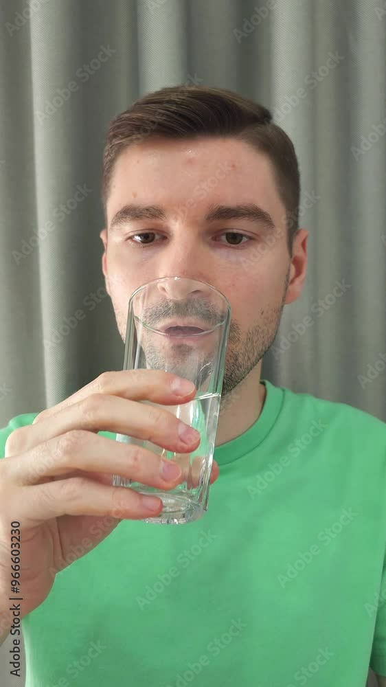Man taking a pill and drinking water from a glass. Health and medication concept for medical awareness campaigns and designs Man taking a pill and drinking water from a glass. Health and medication concept for medical awareness campaigns and designs