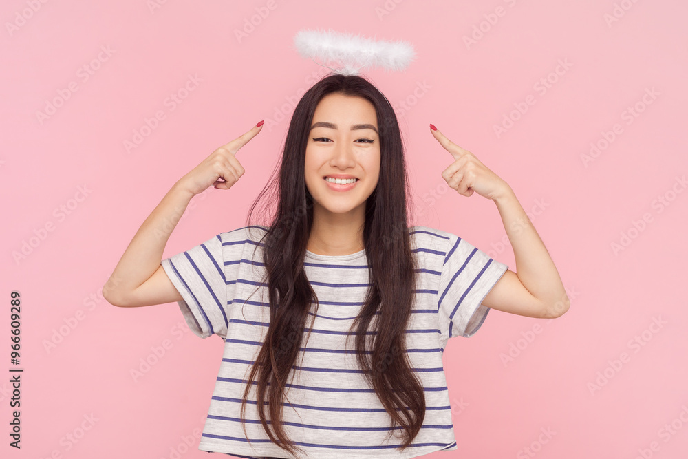 Portrait of smiling satisfied woman with long brunette hair standing pointing at her nimb expressing happiness, wearing striped T-shirt. Indoor studio shot isolated on pink background. Portrait of smiling satisfied woman with long brunette hair standing pointing at her nimb expressing happiness, wearing striped T-shirt. Indoor studio shot isolated on pink background.