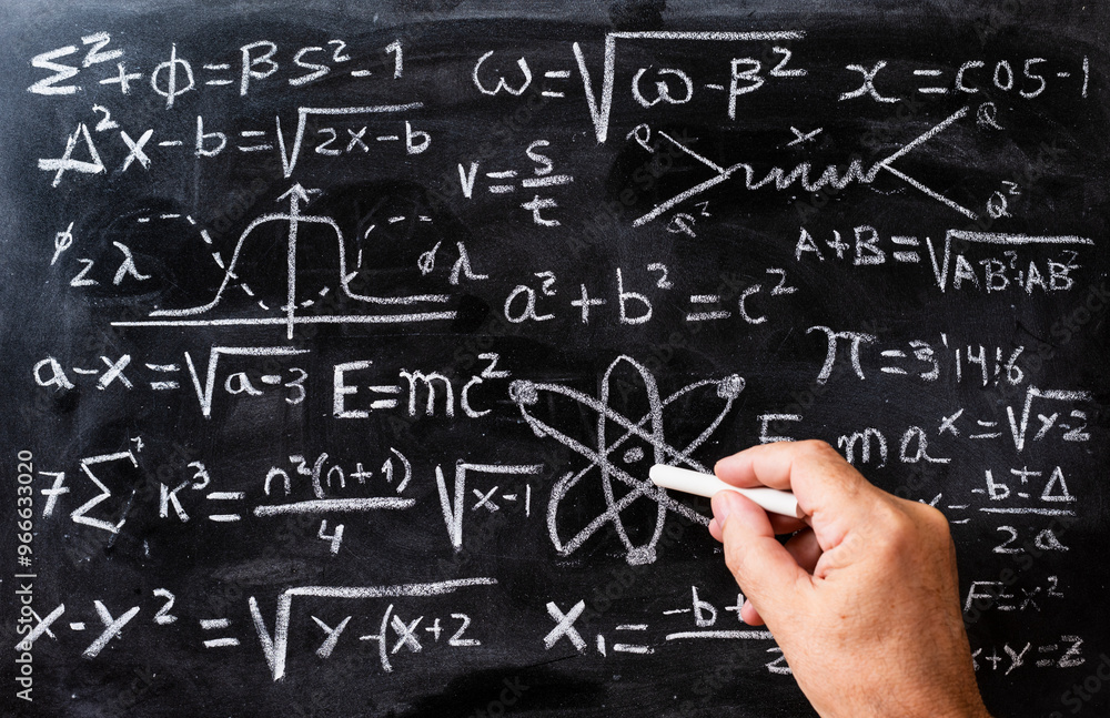 Mano escribiendo operaciones matemáticas y formulas de física cuántica con una tiza en la pizarra Mano escribiendo operaciones matemáticas y formulas de física cuántica con una tiza en la pizarra