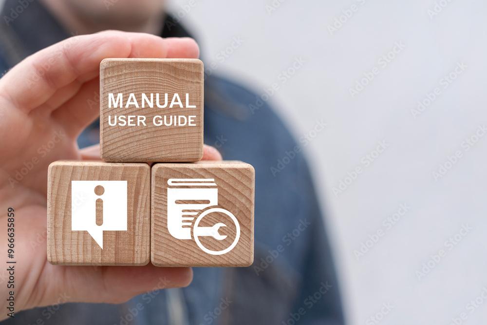 Man holding wooden cubes sees inscription: MANUAL USER GUIDE. Concept of manual user guide. User Manual Guidebook Business Service Communication Internet Technology.
