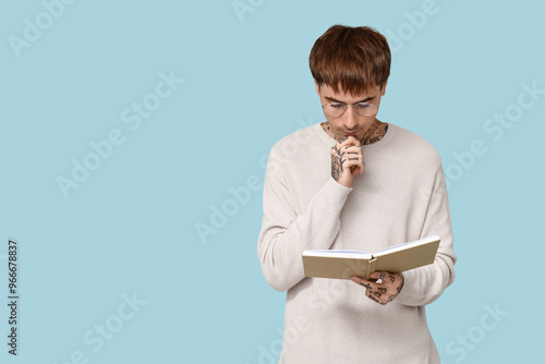 Young tattooed man reading ...