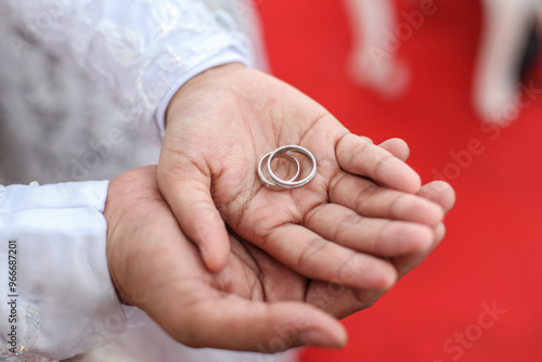 a pair of rings on the hands of the bride and groom, good for article and commercial