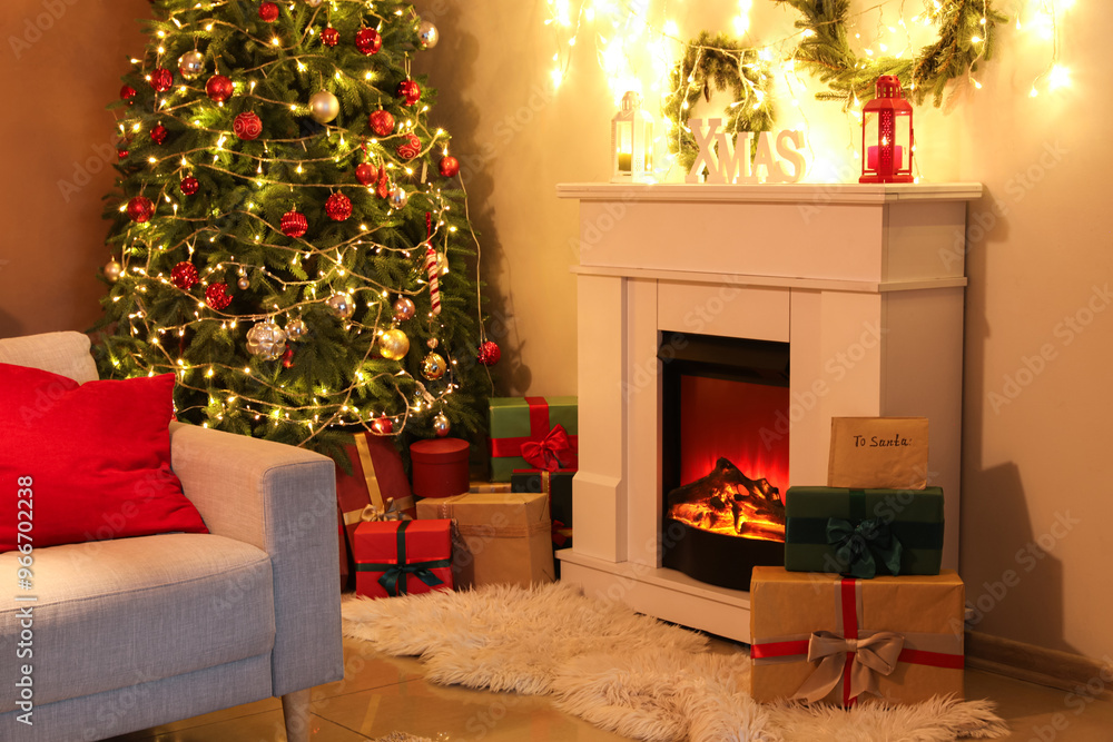 Fototapeta premium Interior of cozy living room with fireplace, glowing garland and gift boxes near Christmas tree at night