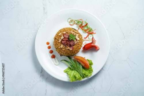 A Plate of Nasi Goreng With Rice, Vegetables, and Sausage on Marble Table