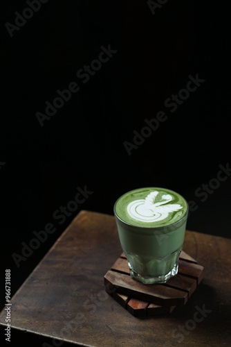 Cup of Matcha Latte With Latte Art on Wooden Table Isolated on Dark Background