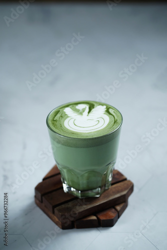 Cup of Matcha Latte With Latte Art on White Marble Table