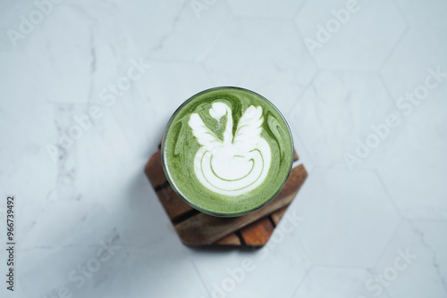 Cup of Matcha Latte With Latte Art on White Marble Table