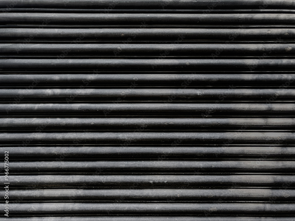 black steel shutter door. grunge black metal bottom and texture of the folding door black steel shutter door. grunge black metal bottom and texture of the folding door