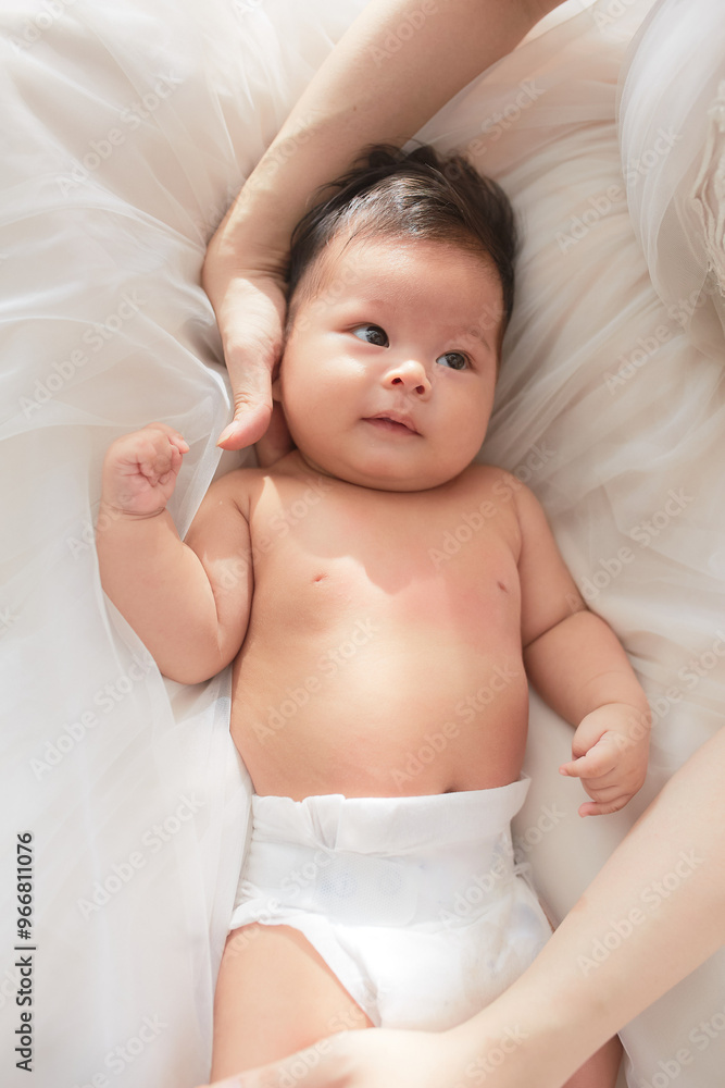 a baby laying on top of a white blanket a baby laying on top of a white blanket