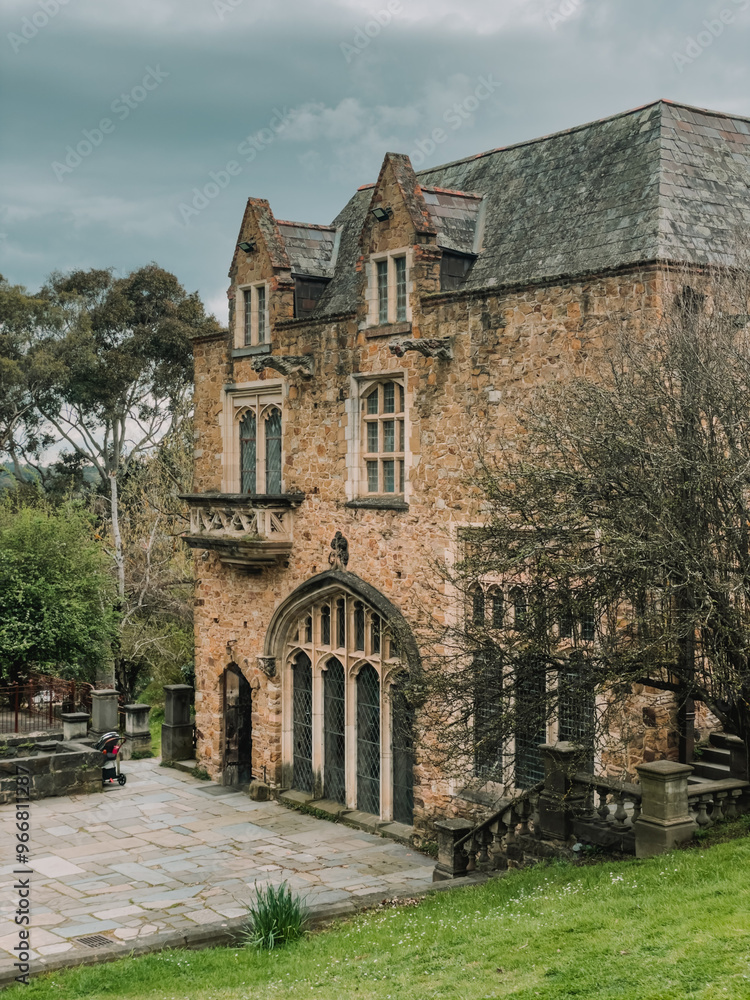 Historic stone building in Montsalvat, Eltham, a famous tourist destination near Melbourne. Surrounded by lush landscaping under cloudy skies, this antique Victorian landmark showcases rich Australia Historic stone building in Montsalvat, Eltham, a famous tourist destination near Melbourne. Surrounded by lush landscaping under cloudy skies, this antique Victorian landmark showcases rich Australia