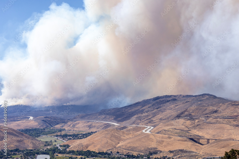 Valley south of Reno. I-580 highway follows the hills with a huge smoke column rising above it Valley south of Reno. I-580 highway follows the hills with a huge smoke column rising above it