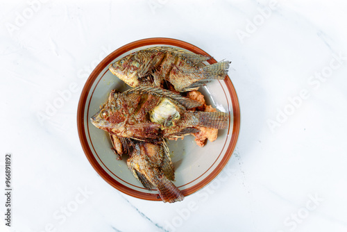 Fried fish served on a white plate. isolated on white background. photo