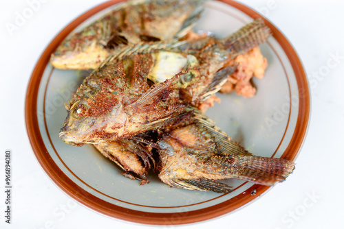 Fried fish served on a white plate. isolated on white background.