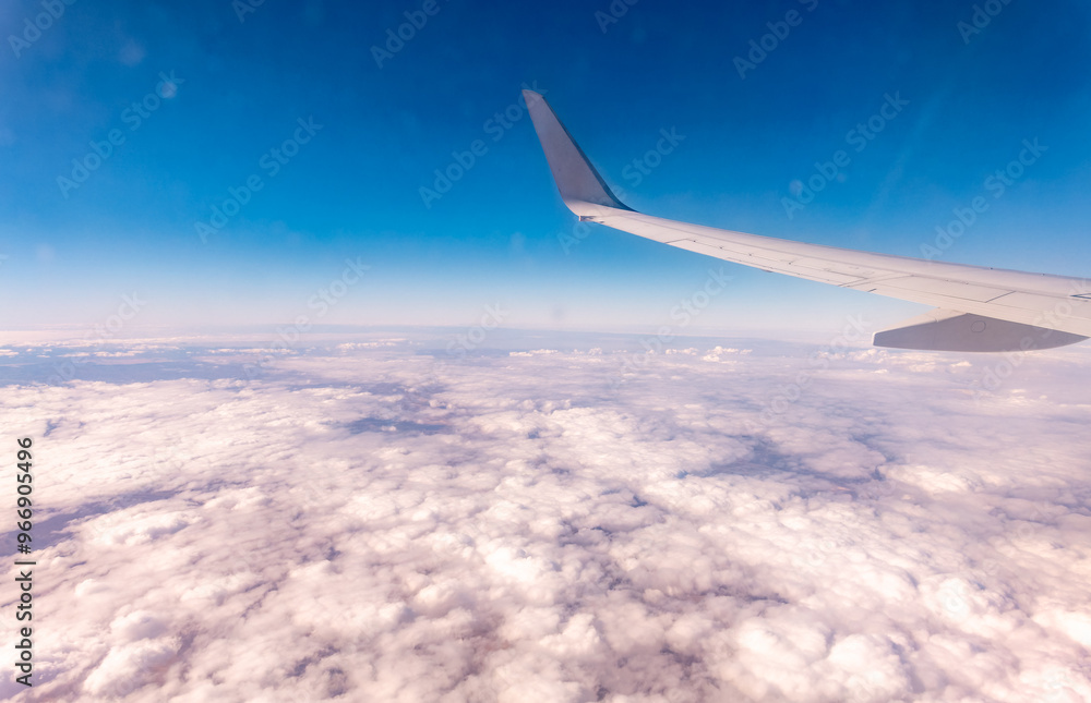 View from the airplane window at a beautiful cloudy sky and the airplane wing View from the airplane window at a beautiful cloudy sky and the airplane wing