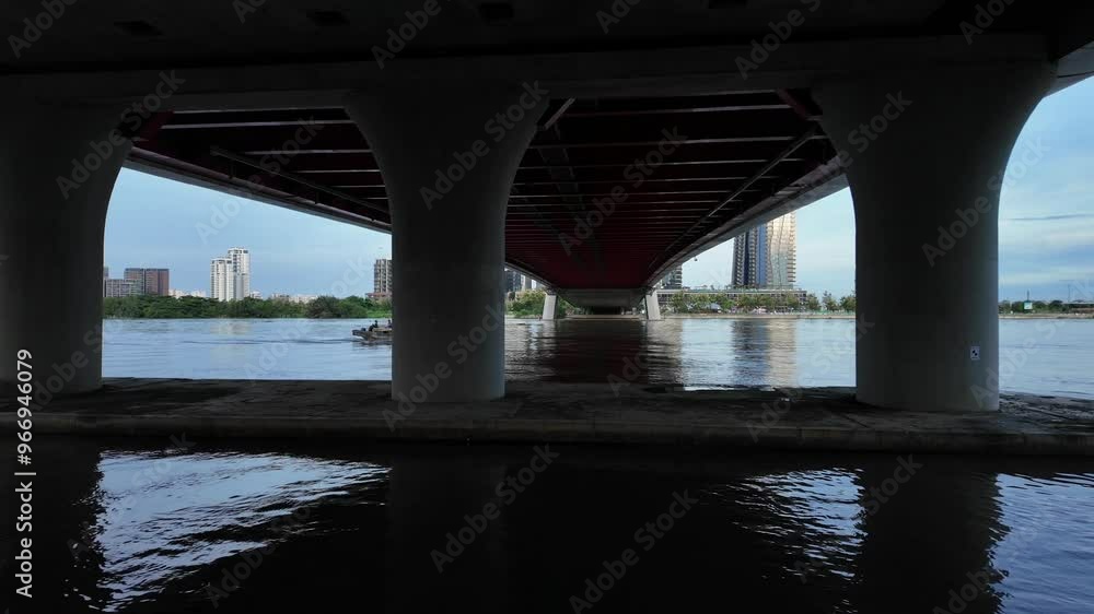 Ba Son cable bridge at Ho Chi Minh city, with big bridge piers, cargo boat cross under modern infrastructure on Sai Gon river