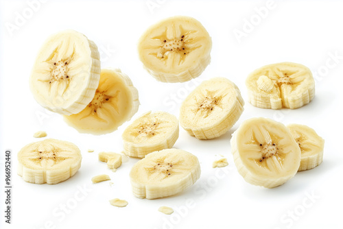 Sliced banana pieces are floating in mid-air against a white background