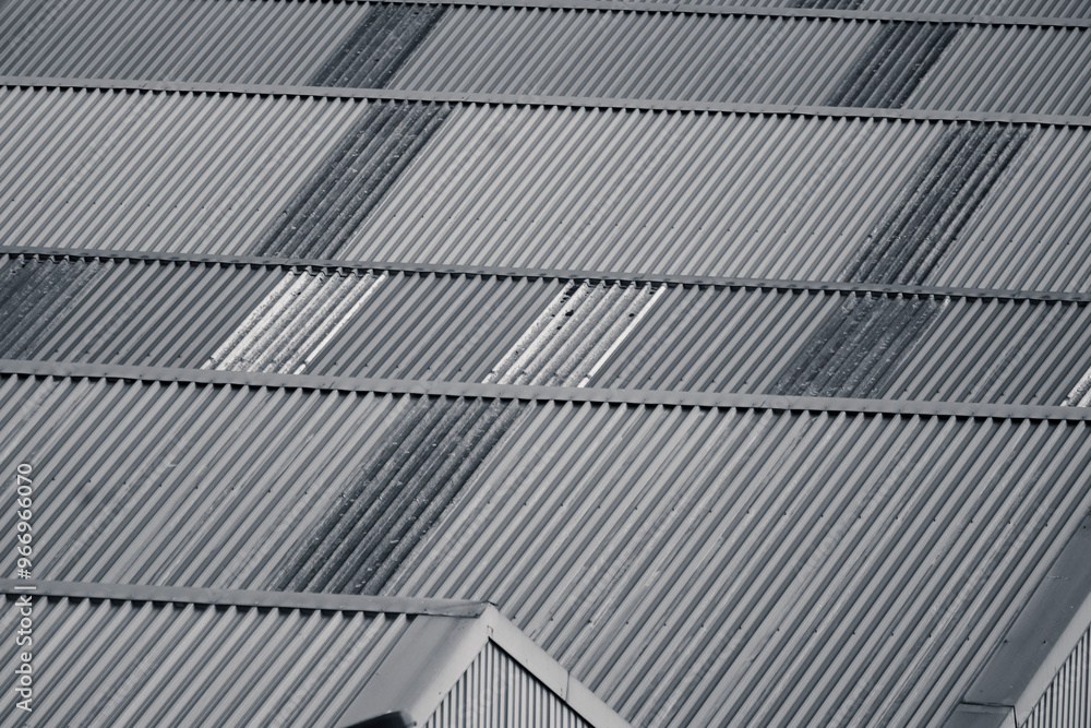 Monochrome view on industrial rooftop with geometric patterns created by the alignment of corrugated metal sheets. Monochrome view on industrial rooftop with geometric patterns created by the alignment of corrugated metal sheets.