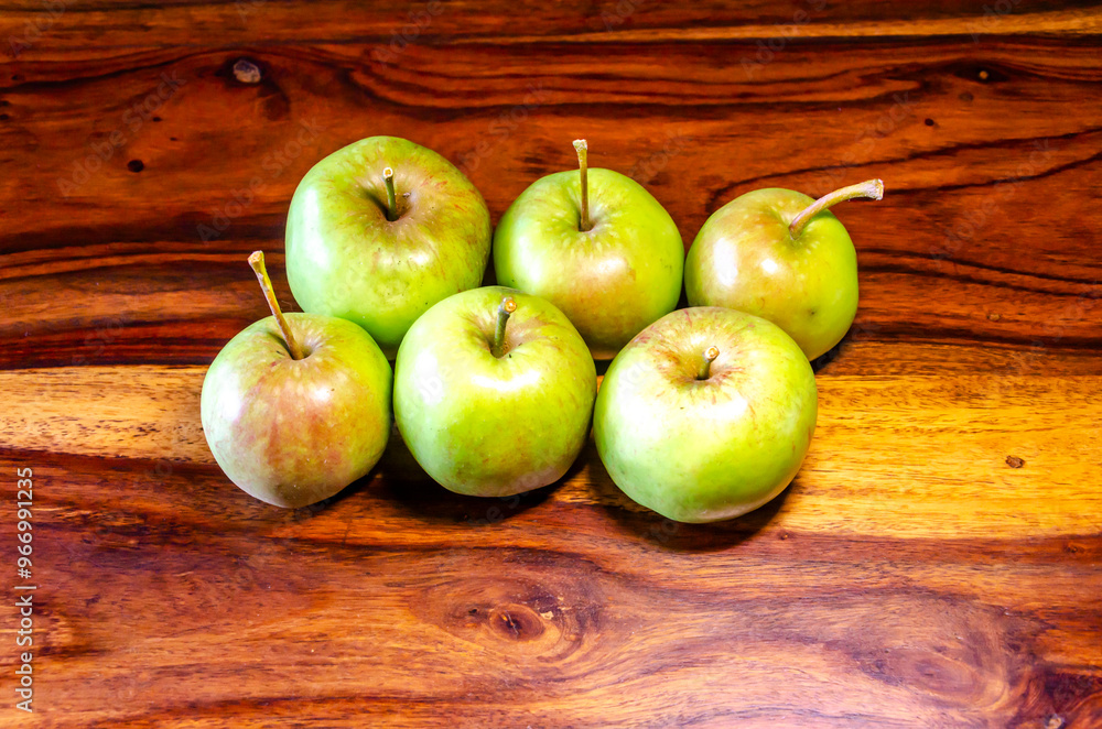 Green apples sitting on a wooden table Green apples sitting on a wooden table