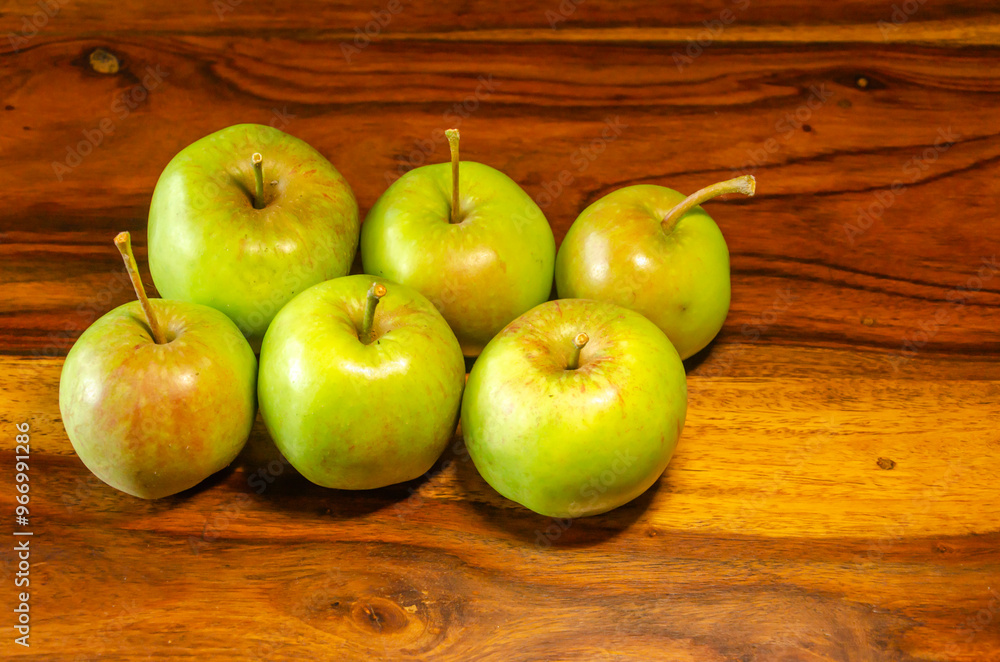 Green apples sitting on a wooden table Green apples sitting on a wooden table