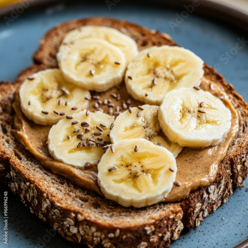 A close-up shot of a toast with peanut butter, banana slices, and flax seeds. photo