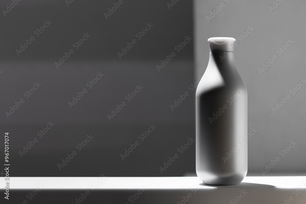 bstract dispenser bottle on white podium at grey background with geometric shape shadow. Cosmetic liquid product like gel or shampoo conditioner visuals bstract dispenser bottle on white podium at grey background with geometric shape shadow. Cosmetic liquid product like gel or shampoo conditioner visuals