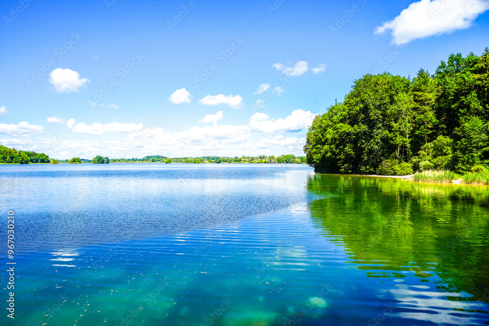 Obraz premium View of Seehamer See and the surrounding landscape in the municipality of Weyarn near Munich. Idyllic nature by the lake with turquoise water. 