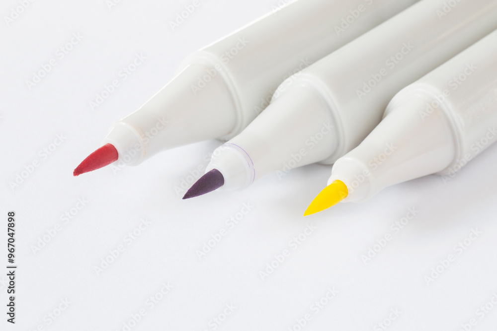 three opened sketch markers lying on white paper three opened sketch markers lying on white paper